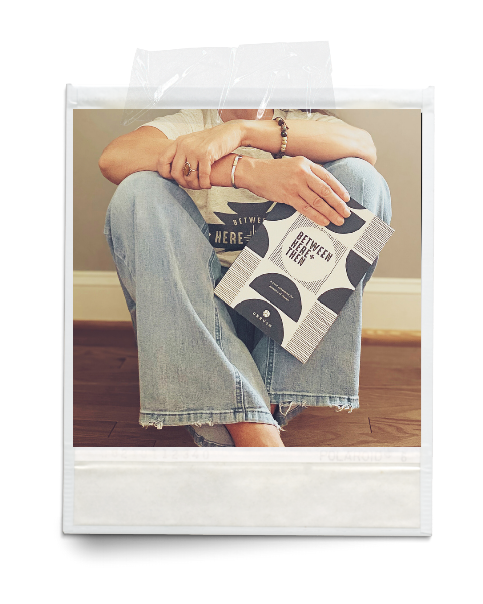 Person holding a journal sitting on a wood floor
